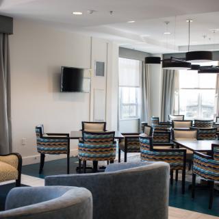 A modern dining area featuring stylish tables and chairs, with large windows and contemporary lighting.