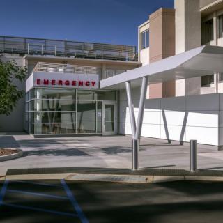 The image shows an exterior view of a hospital emergency entrance.