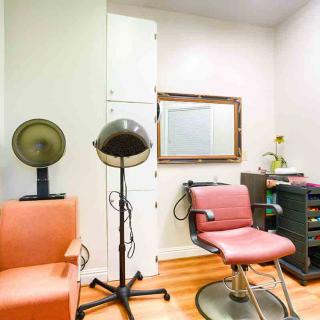 A cozy salon setup featuring chairs and hair dryers with a mirror on the wall.