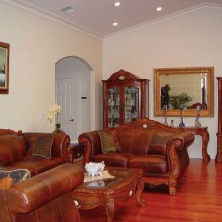 A classical styled living room featuring leather sofas, wooden furniture, and elegant decor.