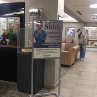 A sign instructing visitors to maintain a quiet environment in a hospital waiting area.