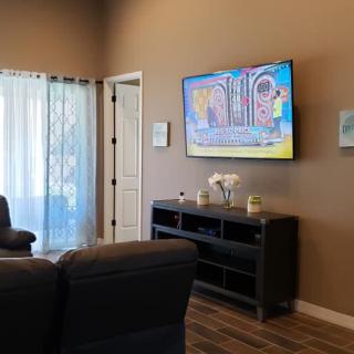 A cozy living room with a television mounted on the wall and comfortable seating.