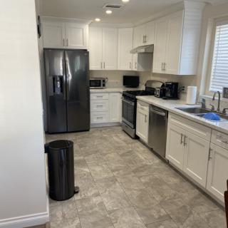 A modern kitchen with stainless steel appliances and white cabinetry.