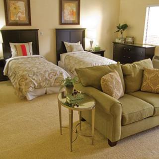 A cozy bedroom with twin beds and a comfortable sofa.