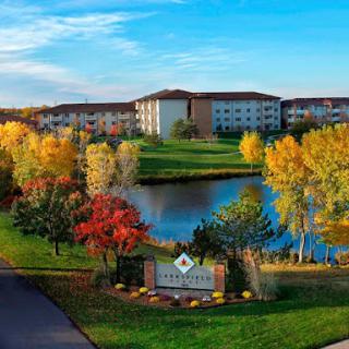 A picturesque view of a resort surrounded by vibrant autumn foliage and a serene lake.
