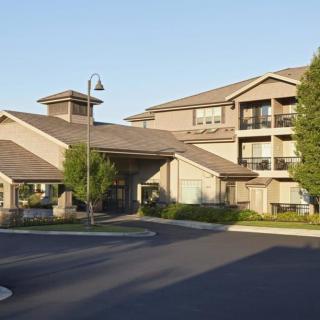A modern apartment complex with well-maintained landscaping during the daytime.