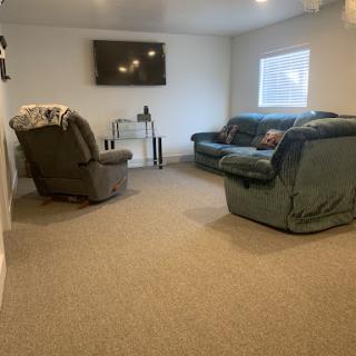A cozy living room featuring comfortable seating and a mounted television.