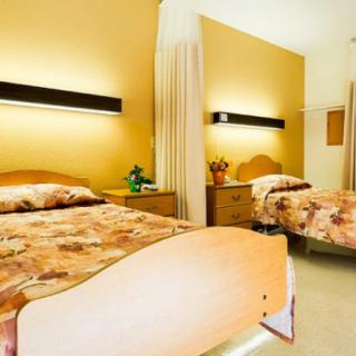 A shared bedroom with two beds, featuring warm lighting and a cozy atmosphere.