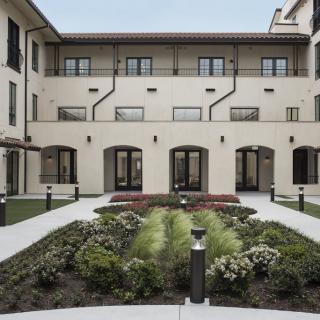 A courtyard with a landscaped garden surrounded by a multi-story building.