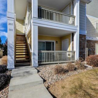 A two-story apartment building with an outdoor staircase and balcony.