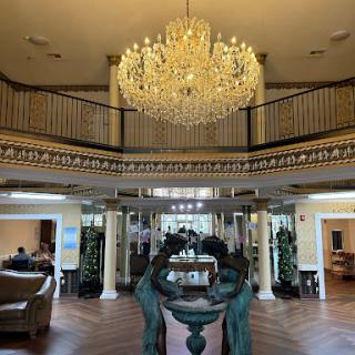 An elegant lobby featuring a stunning chandelier and stylish decor.