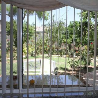 View through a window with metal bars overlooking a garden.
