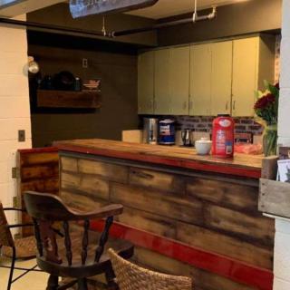 A cozy indoor bar area with a wooden counter and bar stools.