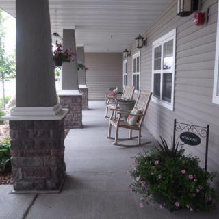 A cozy porch area with rocking chairs and decorative flowers.
