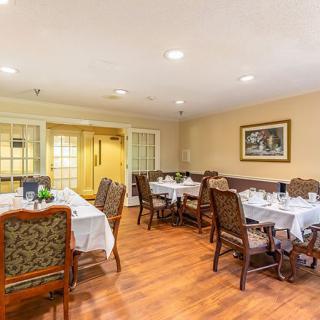 A cozy dining room setup with elegant tables and chairs, ambient lighting, and tasteful decor.