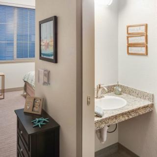 A view of a hotel room showing the bedroom and adjacent bathroom area.
