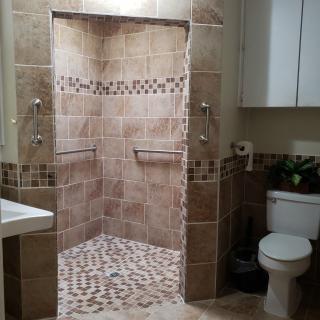 A modern bathroom featuring a walk-in shower with tile design.