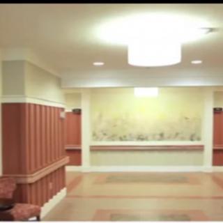A spacious lobby area with decorative wall paneling and lighting.