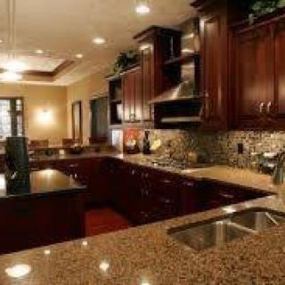 Modern kitchen with dark cabinets and granite countertops.