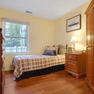 A cozy bedroom with a single bed and wooden furniture.