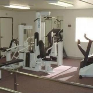 A small gym with various fitness equipment and exercise machines.