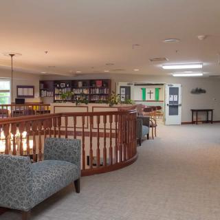A cozy indoor lounge area with seating and wooden railing.