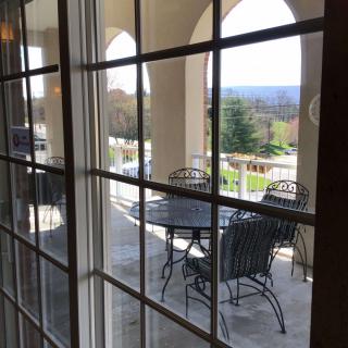 A view of the outdoor patio with a table and chairs through a window.
