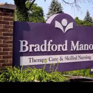 Signage for Bradford Manor, offering therapy care and skilled nursing services.