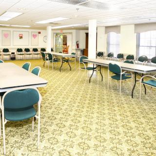 A spacious conference room with arranged tables and chairs, ready for a meeting.