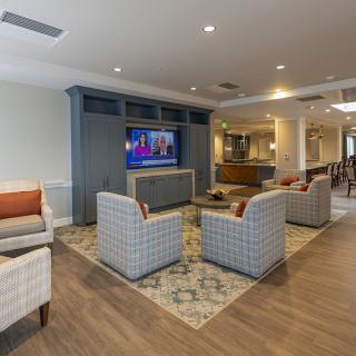 A modern living room with comfortable seating and a large television, featuring a cozy and inviting atmosphere.