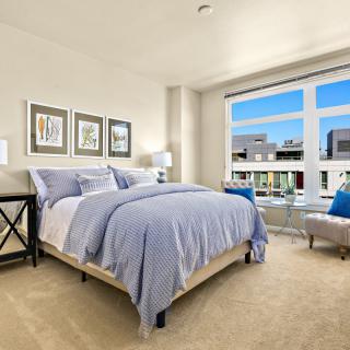 A modern bedroom with a large window offering a bright, comforting atmosphere.