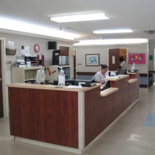 A view of a medical reception area with staff attending to tasks.