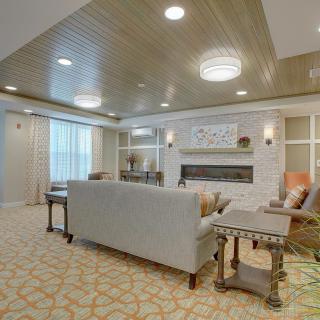 A cozy living room with a sofa, tables, and a fireplace.