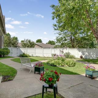 A tranquil backyard garden with a pathway and blooming flowers.