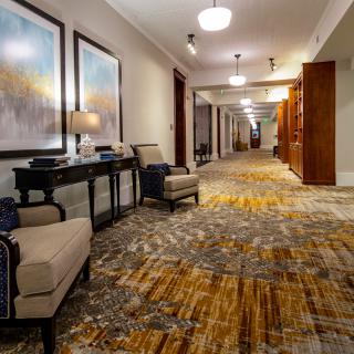 A spacious and well-decorated hallway with artwork and comfortable seating.