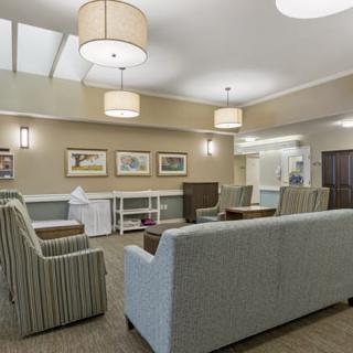 A cozy and modern living room with sofas, chairs, and warm lighting.