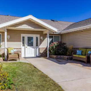 A welcoming entrance to a residential home, featuring a well-maintained pathway and seating area.