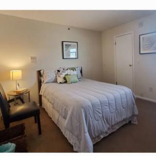 A cozy bedroom with a neatly made bed and simple decor.