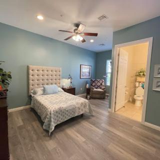 A serene and inviting bedroom with a blue color scheme, featuring modern furniture and ample natural light.