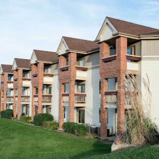 A row of modern residential buildings with well-maintained landscaping in a suburban setting.