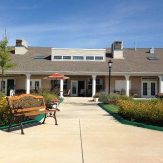 A scenic view of a building with a bench and garden in the foreground.