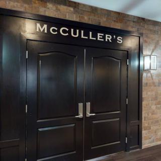 Entrance to McCULLER'S restaurant with double doors against a brick wall.