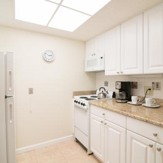 A bright kitchen with white cabinets and modern appliances.