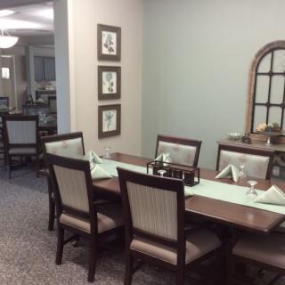 A well-decorated dining room with a large table and chairs, featuring tasteful decor.