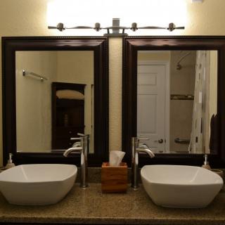 A modern bathroom with double sinks and large framed mirrors.