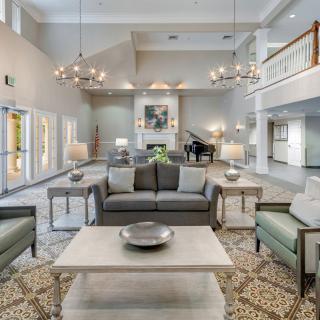 A spacious and elegantly decorated lobby featuring comfortable seating and modern chandeliers.