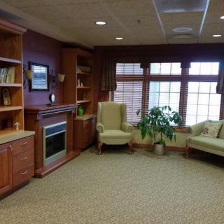 A cozy living room with a fireplace, bookshelves, and comfortable seating.
