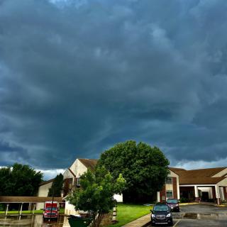 A stormy sky looms over a residential neighborhood with dark clouds gathering above.
