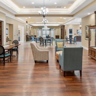 A spacious and well-lit lounge area with comfortable seating and hardwood flooring.