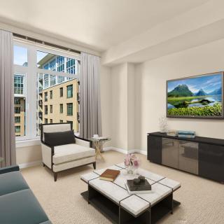 A modern living room featuring stylish furniture and a large window with an urban view.